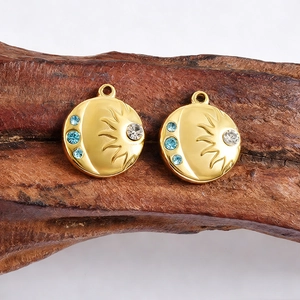 Macro shot of gold sun and moon pendants with blue rhinestones on a wood block