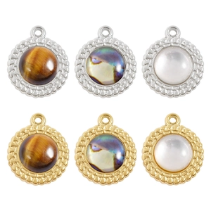 Detailed view of 18k gold and silver pendants with tiger eye and mother of pearl