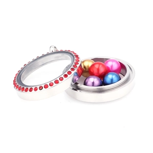 Détail du médaillon rond en acier de 30mm avec strass rouges et 5 perles de couleur
