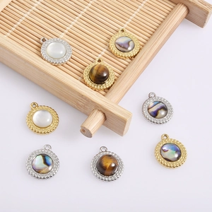 Close-up of 18k gold and silver pendants with natural shell and tiger eye stone inlays