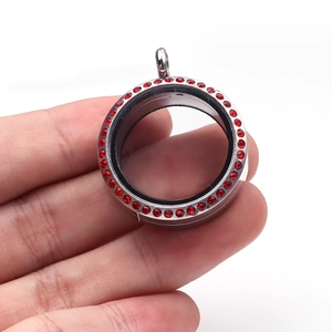 Détail d'un médaillon rond de 30mm en acier inoxydable avec des strass rouges brillants