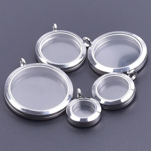 Macro detail of five polished stainless steel glass locket pendants in various sizes