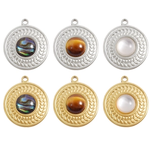 Macro shot of round stainless steel pendants with wheat pattern edges and shell inlays