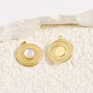 Detailed macro view of 18k gold plated round pendants with pearl and woven texture