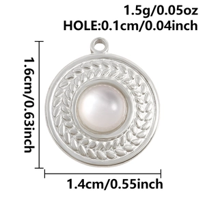 Detail view of round steel pendant with leaf pattern, pearl center and size markings
