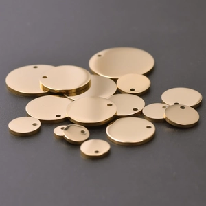 Detailed view of polished gold stainless steel circular pendants in various sizes