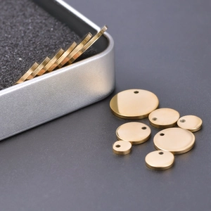 Detailed macro view of mirror polished gold stainless steel round charms for DIY jewelry