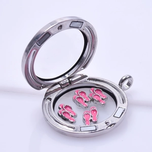Close-up of a silver floating locket with pink flip-flop charms in polished stainless steel