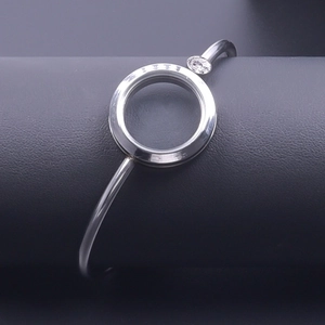 Detail view of silver stainless steel open bangle with engraved ring and small crystal