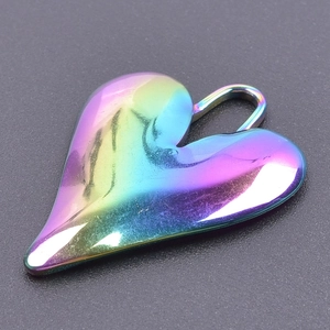 Macro detail of heart-shaped stainless steel pendant with polished rainbow gradient finish