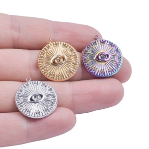 Three round evil eye pendants in gold, silver, and rainbow colors with sunburst pattern