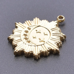 Golden sun and moon celestial pendant with stars on textured dark grey background
