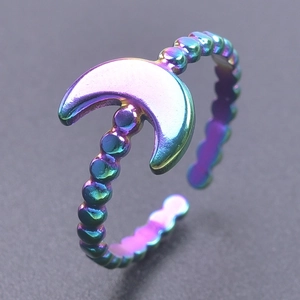 Macro detail of rainbow stainless steel open ring with crescent moon and beaded band design