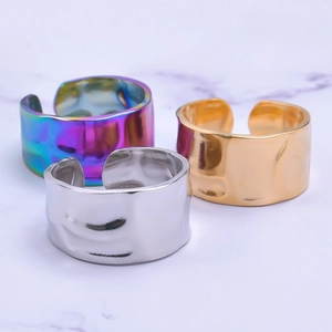 Macro shot of colorful, gold, and silver adjustable stainless steel rings with hammer texture