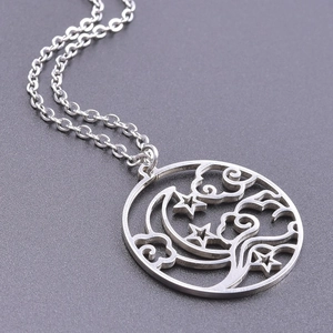 Macro shot of silver hollow-out moon and star pendant with sleek stainless steel chain