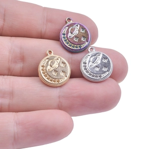 Three celestial pendants featuring moon and planet designs in colorful gold and silver