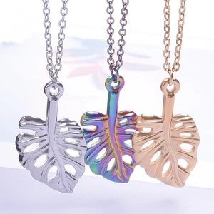 Trois pendentifs feuille de monstera en acier inoxydable or, argent et arc-en-ciel