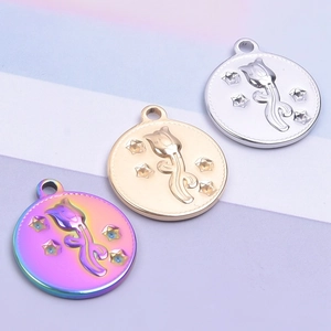 Détail macro de pendentifs ronds gravés de tulipes et d'étoiles en or, argent et arc-en-ciel