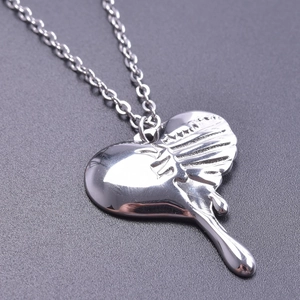 Macro shot of polished silver heart pendant with unique liquid melting design effect