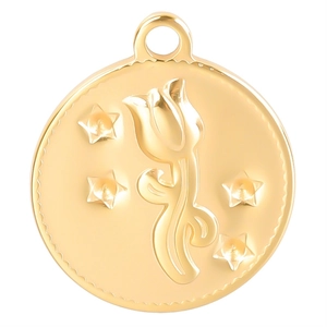 Vue macro d'un pendentif rond en acier inoxydable doré avec motif floral de tulipe
