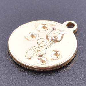 Gros plan d'un pendentif tulipe doré gaufré avec détails d'étoiles et poli miroir