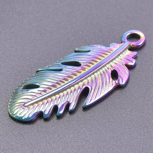 Vue macro d'un pendentif plume en acier inoxydable arc-en-ciel avec design ajouré
