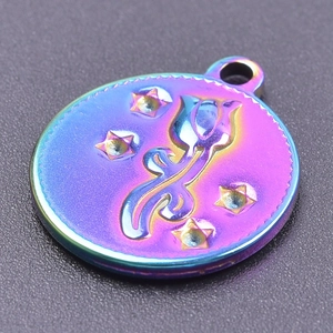 Vue macro d'un pendentif rond en acier inoxydable coloré avec tulipe et étoiles