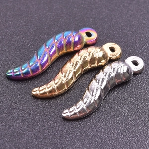 Macro detail of chili-shaped pendants in rainbow, gold, and silver stainless steel