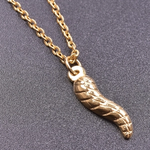 Macro shot of gold 18K stainless steel chili pendant with spiral texture detail