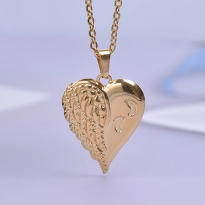 Dettaglio del ciondolo a cuore in oro 18k con ala d'angelo e impronte di piedini