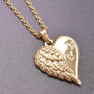 Dettaglio macro della collana a cuore placcata oro 18k con ala d'angelo e piedini