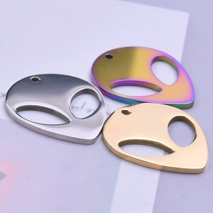 Macro shot of alien head charms in silver, gold, and rainbow stainless steel finishes