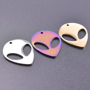 Detail of alien head pendants in gold, silver, and rainbow colors with hollow eyes