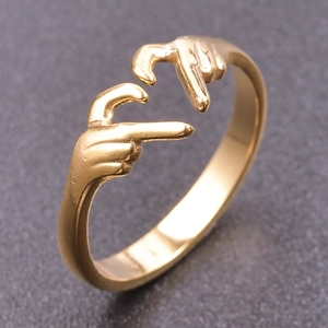 Detail of adjustable gold stainless steel ring with creative hands holding design