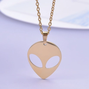 Detail shot of a 18K gold-plated alien head pendant with hollow eyes on a thin chain