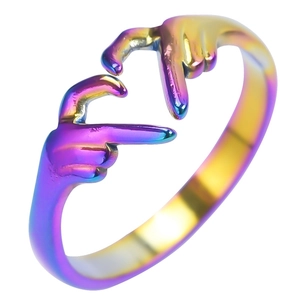 Macro shot of rainbow-colored titanium steel ring with creative heart gesture hand shape