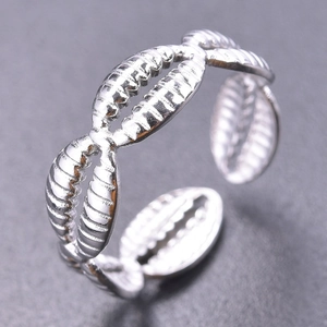 Macro shot of silver titanium steel open ring showing detailed shell and leaf textures