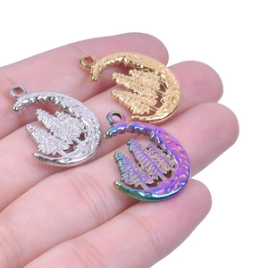 Close-up of stainless steel crescent moon and pine tree pendants in three colors