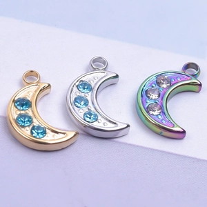 Detailed macro view of 18K gold and silver moon pendants with inlaid sparkling rhinestones