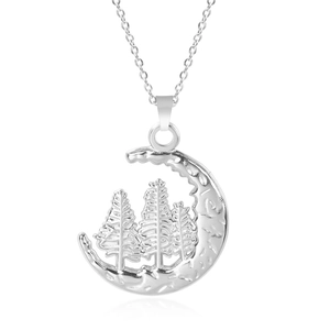 Macro detail of crescent moon and pine tree pendant in minimalist silver finish