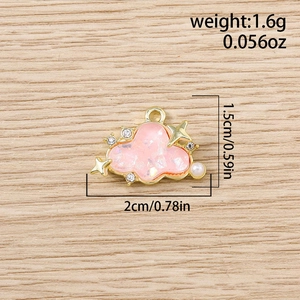 Macro shot of pink cloud pendant with rhinestones and pearls on light wood background