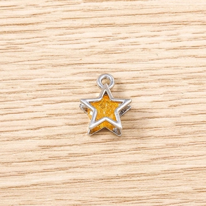 Macro detail of star-shaped DIY pendant with silver metallic border and orange glitter fill