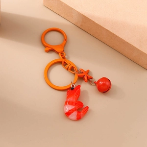 Detail eines Garnelen-Schlüsselanhängers mit roter Glocke und orangefarbenem Karabiner