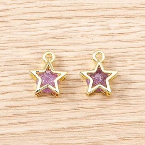 Detail of star-shaped purple charms with gold metal frames for DIY jewelry making
