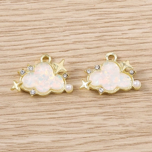 Close-up of cloud shaped jewelry pendants with opal inlay, pearls and star charms