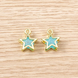 Macro shot of light blue star charms with gold frames on a rustic wooden background