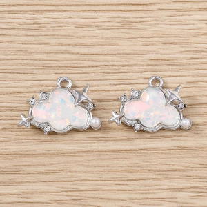 Macro shot of cloud-shaped pendants with sparkling rhinestones, star accents and white pearls