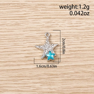 Macro view of starfish metal pendant with blue star inlay on light wood background