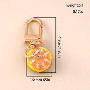 Detailed view of orange slice keychain with dimensions and weight measurements