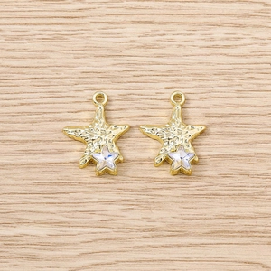 Detail of star-shaped golden pendants with iridescent crystals for DIY jewelry making